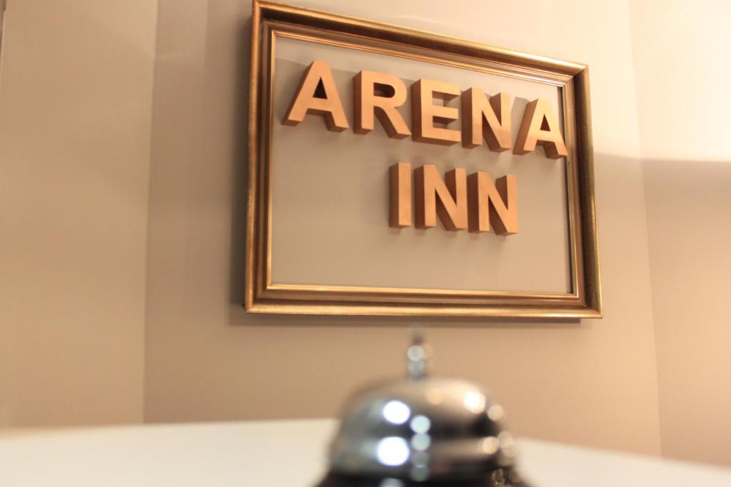 a picture of an american inc sign on a wall at Hotel Arena Inn - Berlin Mitte in Berlin