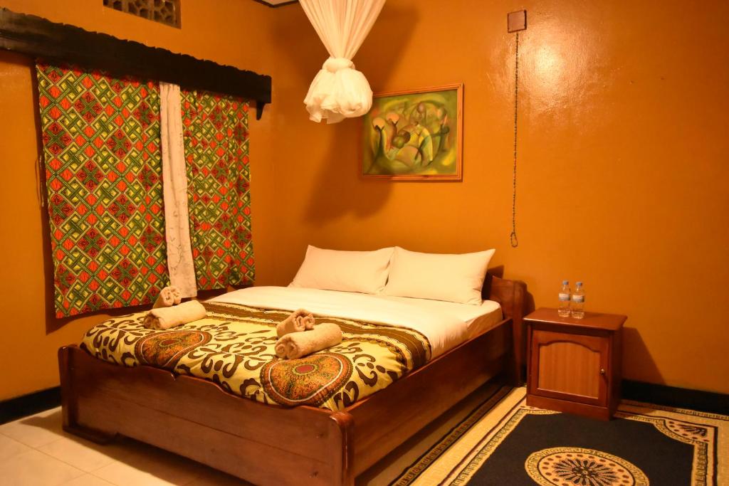 A bed or beds in a room at Amahoro Guest House
