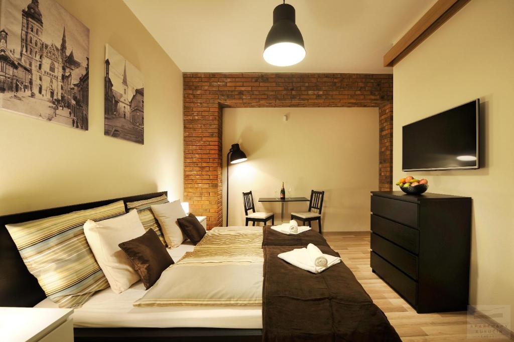 1 dormitorio con 1 cama y 1 mesa con sillas en Apartmány Kukučín en Košice