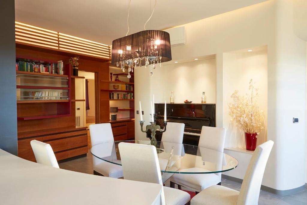 una sala da pranzo con tavolo in vetro e sedie bianche di Vatican Luxury Penthouse with Terrace a Roma