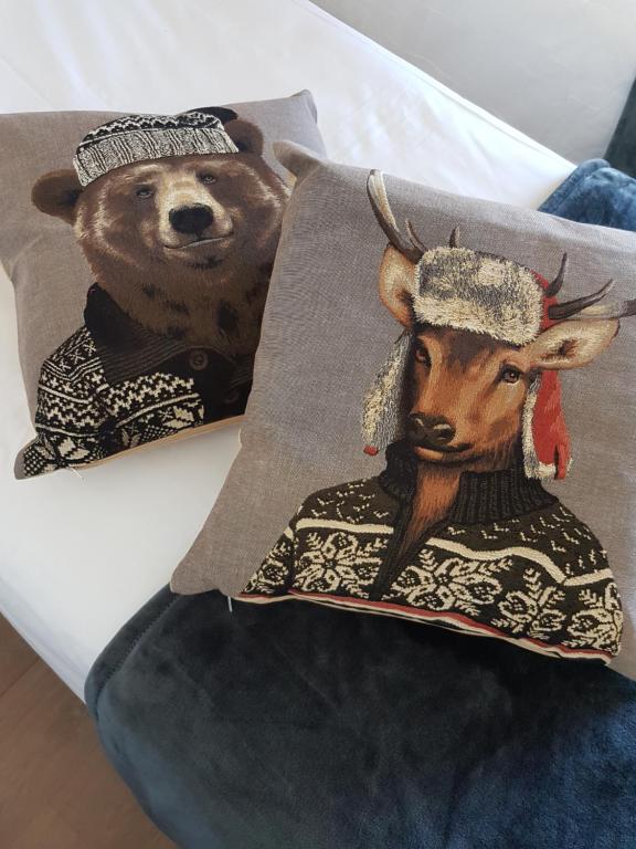 Una almohada con un oso y un ciervo. en Hôtel Yaka en Les Angles