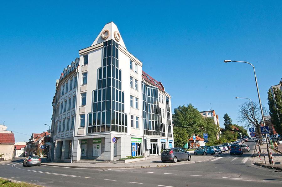 duży biały budynek na rogu ulicy w obiekcie VaBank Apartamenty w centrum w Zielonej Górze