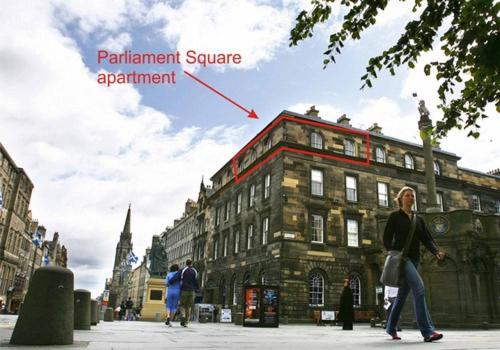 a woman walking down a street in front of a building at Parliament Sq (apt 15) Royal Mile in Edinburgh