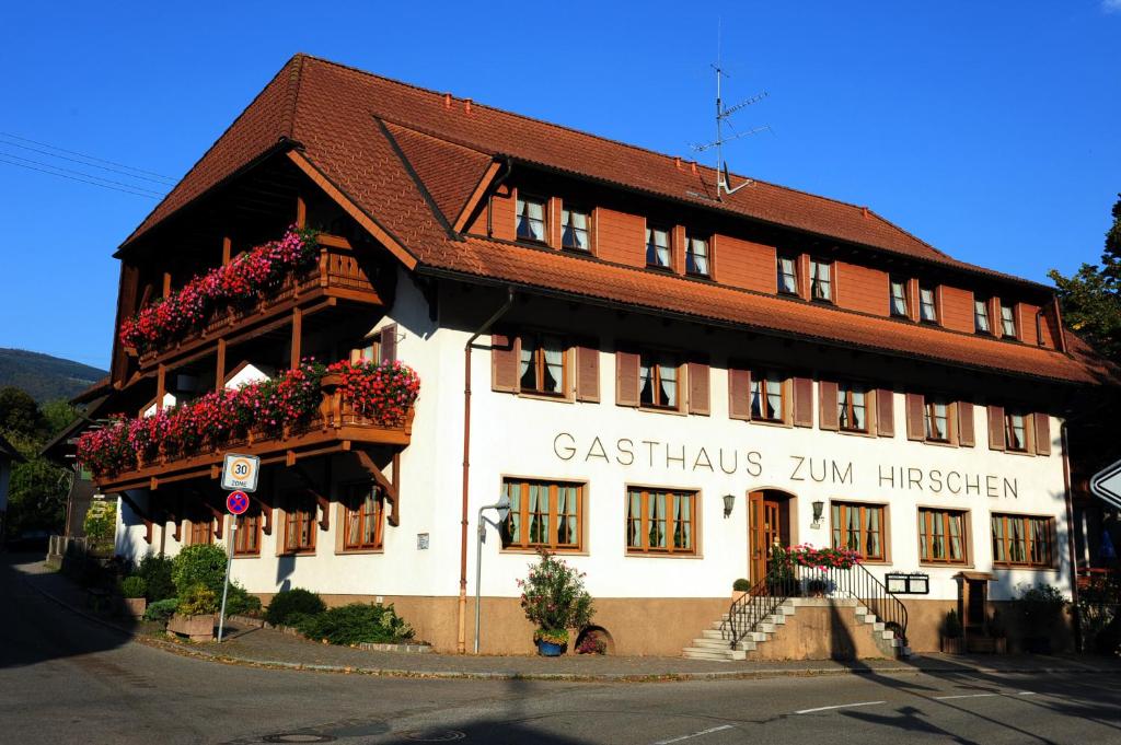 un edificio con cajas de flores en la parte delantera en Hotel Gasthaus Zum Hirschen, en Simonswald