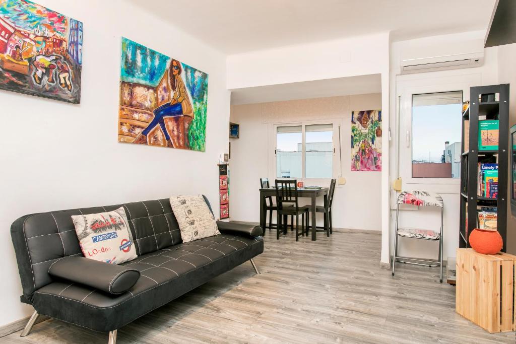 a living room with a black couch and a table at Apartamento BaBa in Hospitalet de Llobregat