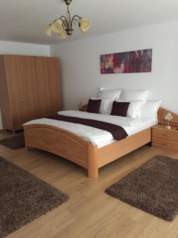 sypialnia z dużym łóżkiem z białą pościelą i poduszkami w obiekcie Xenopol Grand Studio w Sybinie