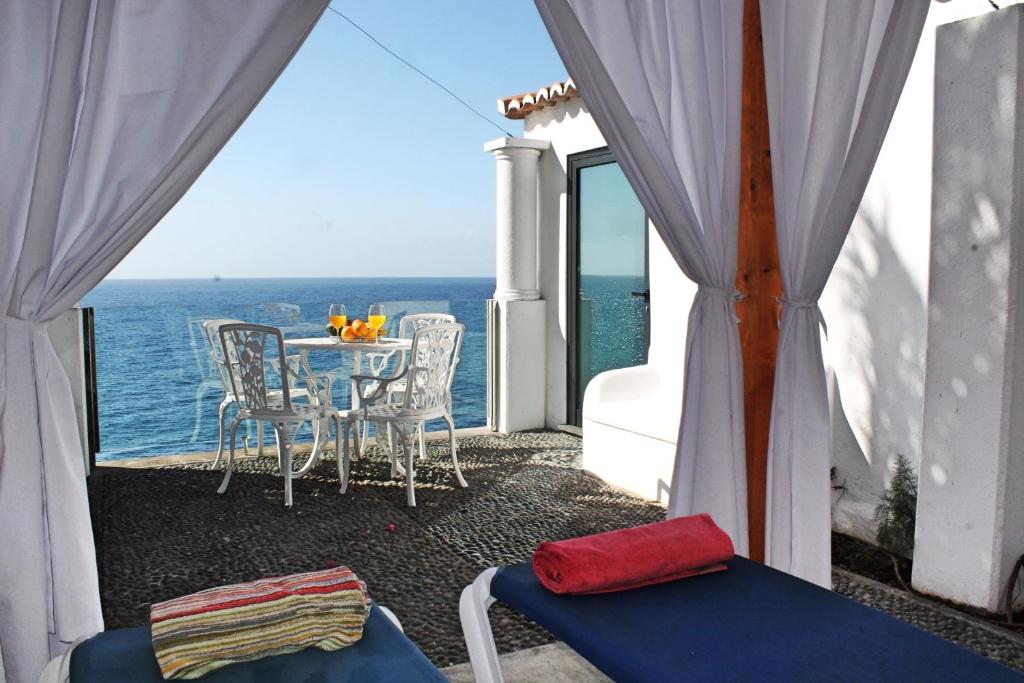 balcone con tavolo, sedie e vista sull'oceano di OurMadeira - Cottage do Mar, secluded ad Arco da Calheta