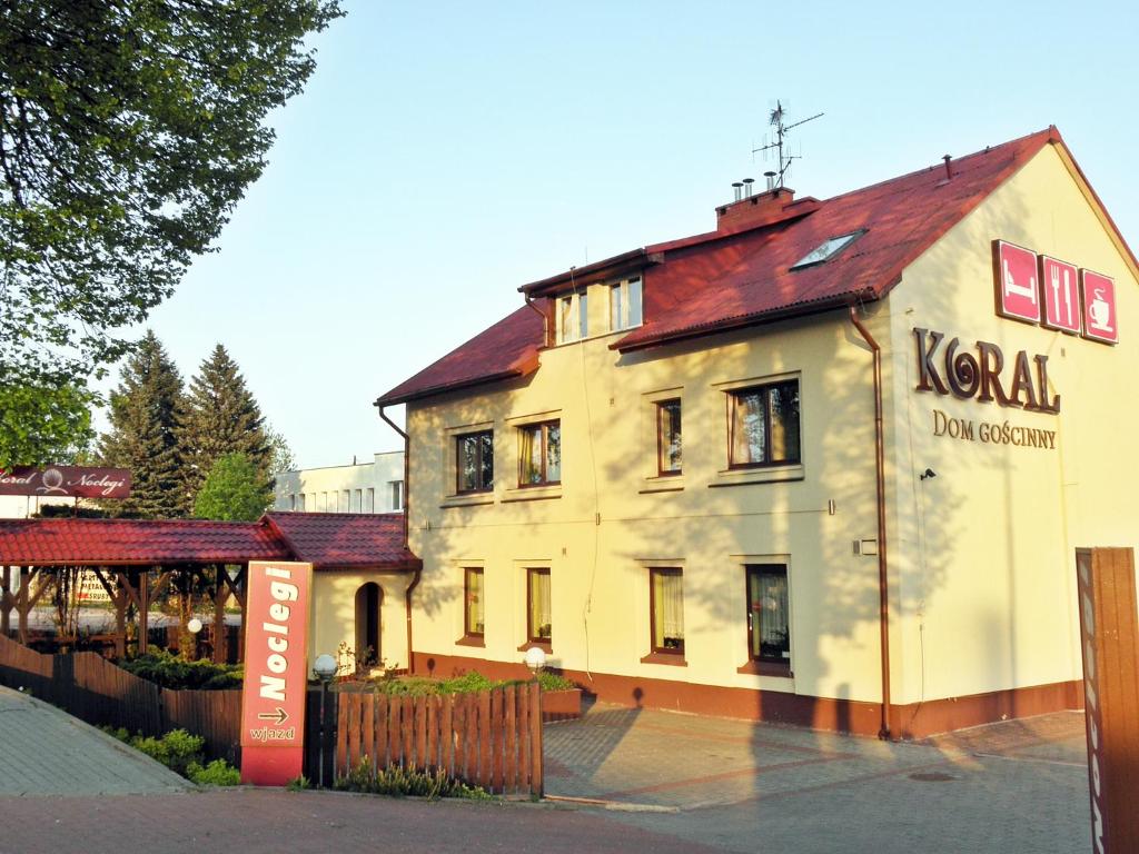 a large white building with a sign in front of it at Koral in Koszalin