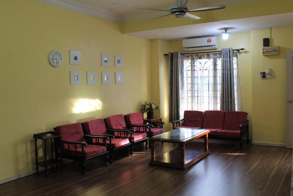 een wachtkamer met rode stoelen en een tafel bij Nilai Impian Homestay @ Dillenia in Nilai