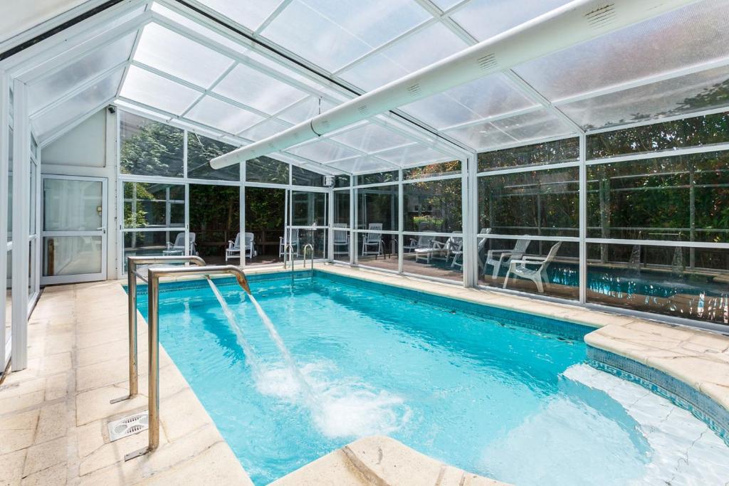 an indoor swimming pool with a glass ceiling at Colina Blanca Apart in Mar de las Pampas