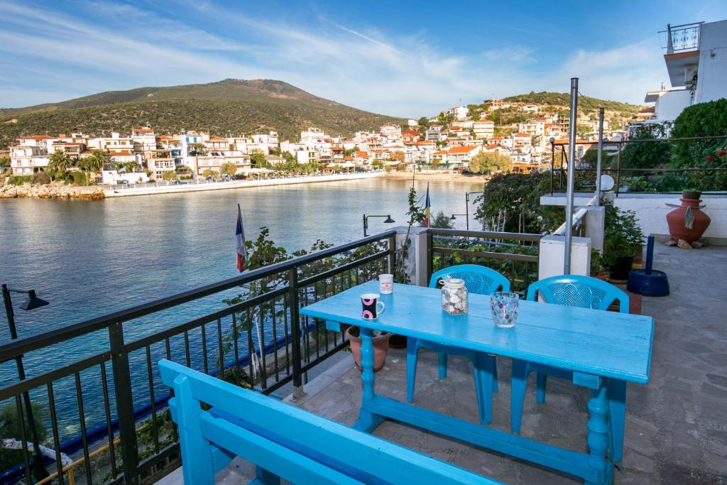 een blauwe tafel op een balkon met uitzicht op een waterlichaam bij Evaggelia Nikolaki Sea View in Skala Marion