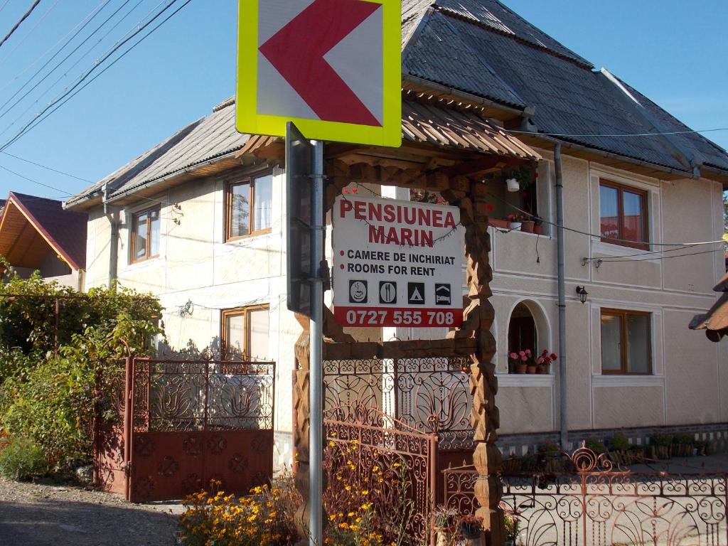 a street sign in front of a house at Pensiunea Marin in Rona de Jos
