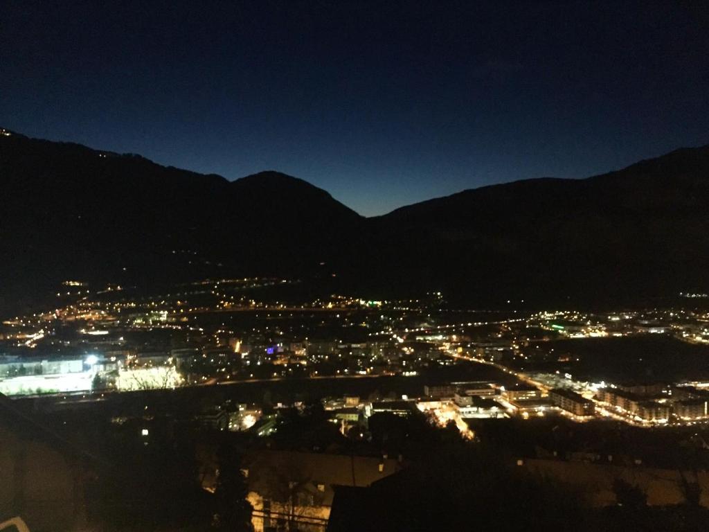 a view of a city lit up at night at Casa Lampone in Trento