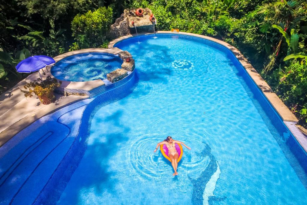 een uitzicht op een vrouw in een zwembad bij The Goddess Garden Eco-Resort in Cahuita