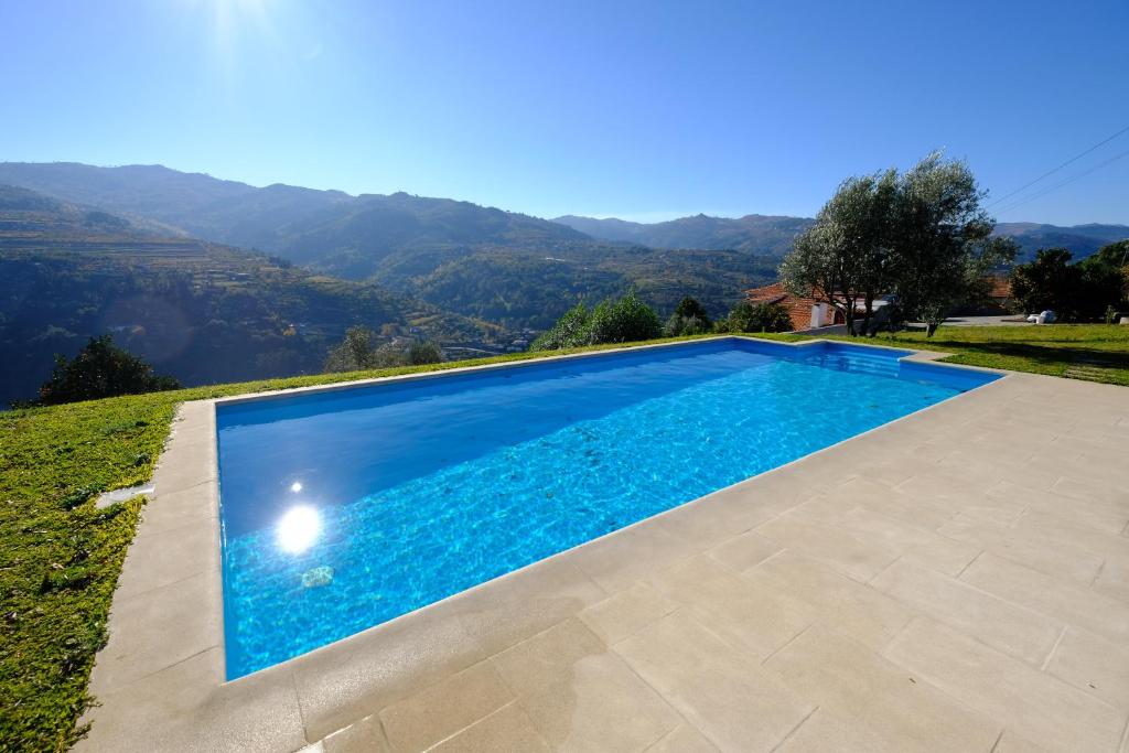 una piscina en una villa con montañas en el fondo en Casas do Casinhoto - Casa com Vista Douro en Baião