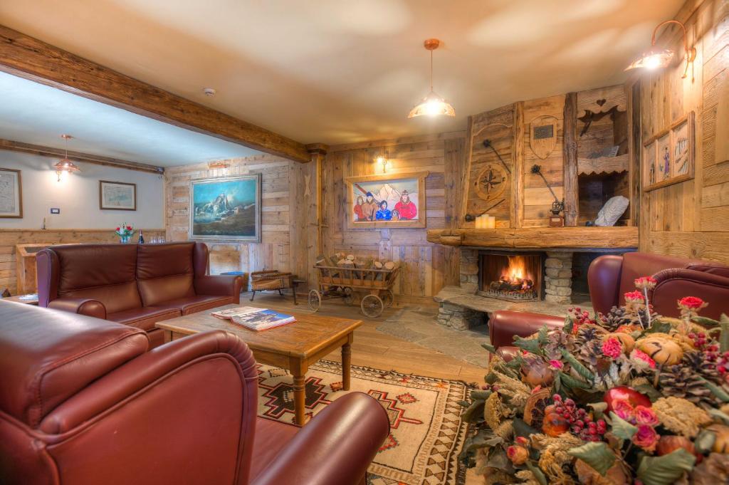 sala de estar con muebles de cuero y chimenea en Hotel Meublé Mon Rêve, en Breuil-Cervinia