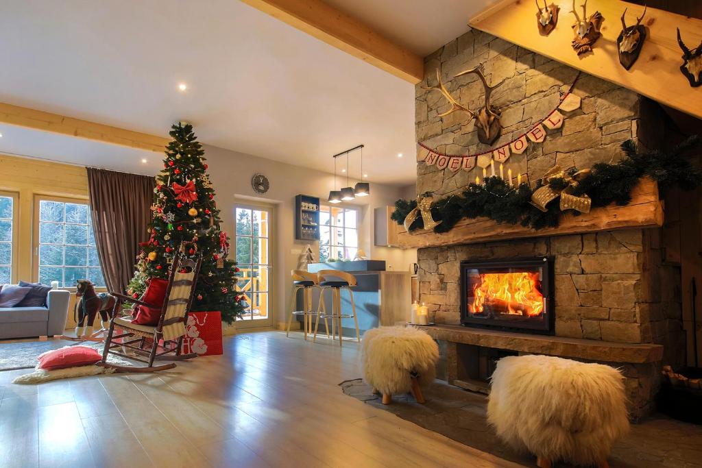 a living room with a christmas tree and a fireplace at Domek nad Potokiem in Nowy Targ