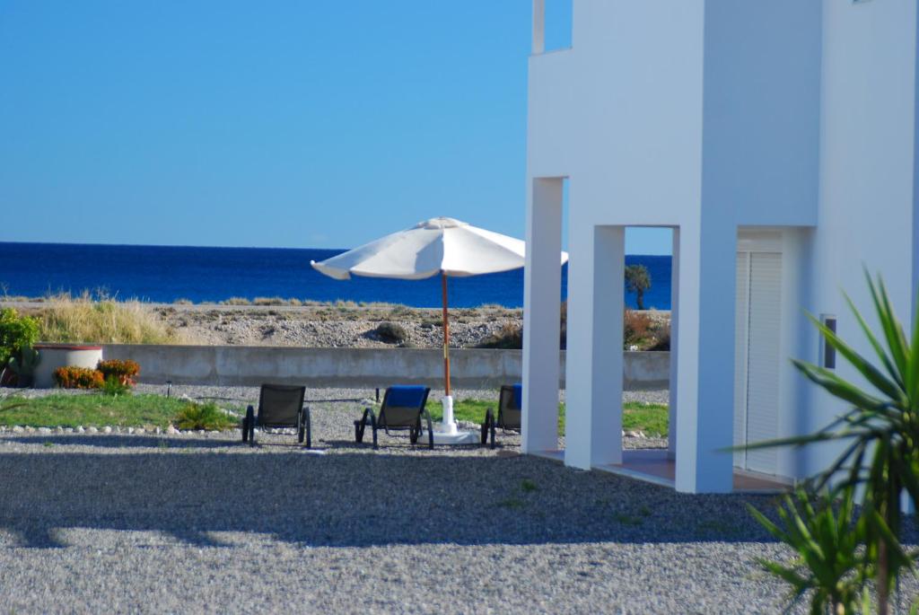 a patio with two chairs and an umbrella at Villa Mangano in Afantou
