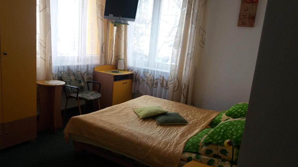 a small bedroom with a bed and a television at Bursztynek in Gdynia