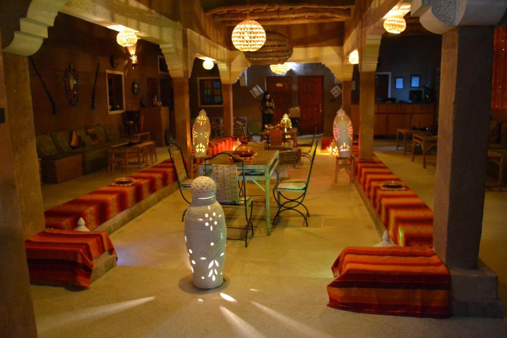 瓦尔扎扎特里亚德萨拉雅思酒店的一间设有橙色椅子、桌子和一瓶水的房间