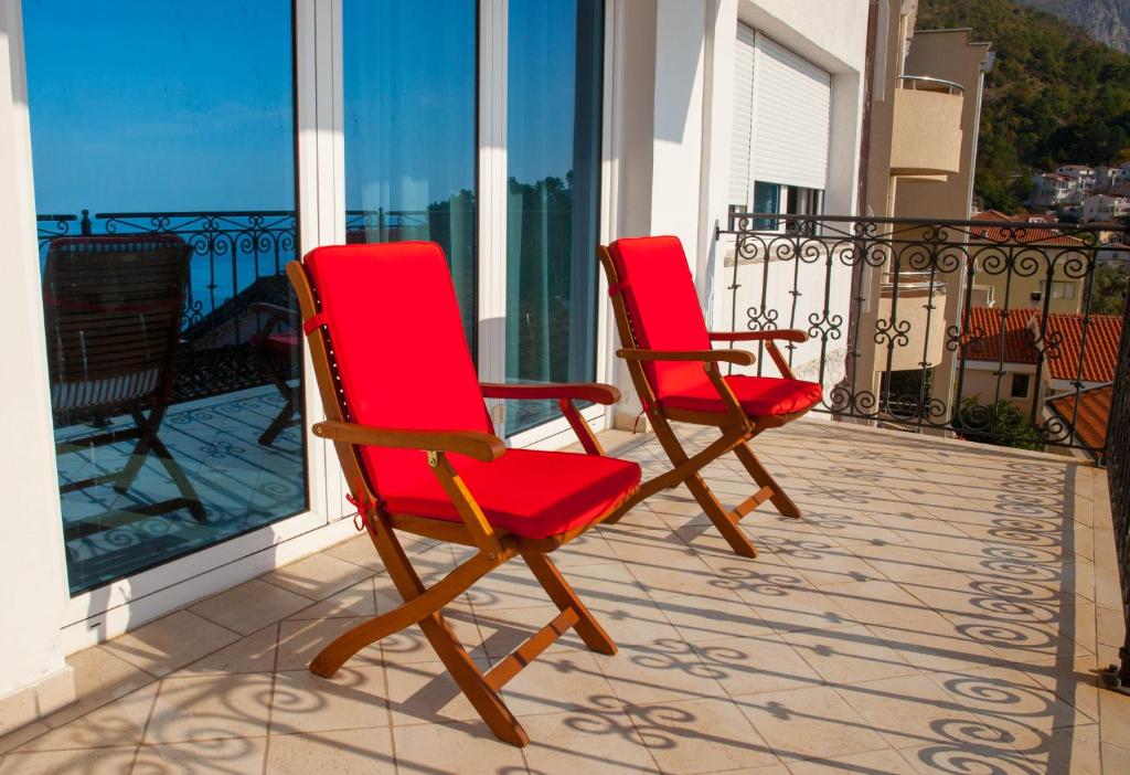 two red chairs sitting on a balcony at Villa Edelweiss in Sveti Stefan