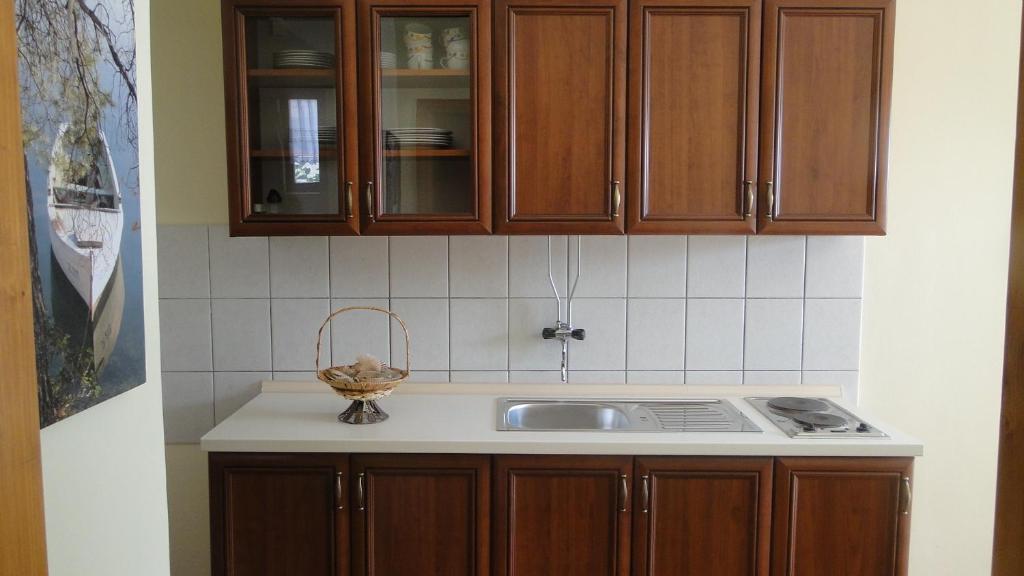 a kitchen with wooden cabinets and a sink at Villa Agava in Vrboska