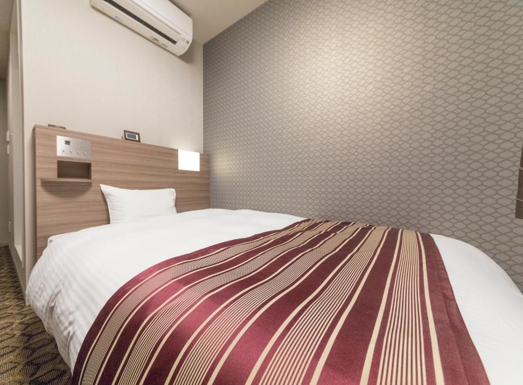 Postel nebo postele na pokoji v ubytování Hotel WBF Namba Motomachi