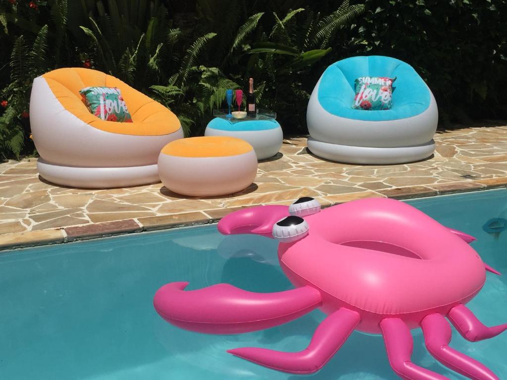 a group of inflatables sitting next to a swimming pool at Suítes da Piscina in Ilhabela