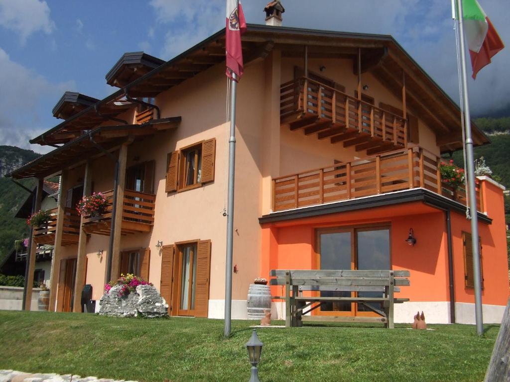 un bâtiment avec un banc devant lui dans l'établissement Agritur Le Pergole, à Villa Lagarina