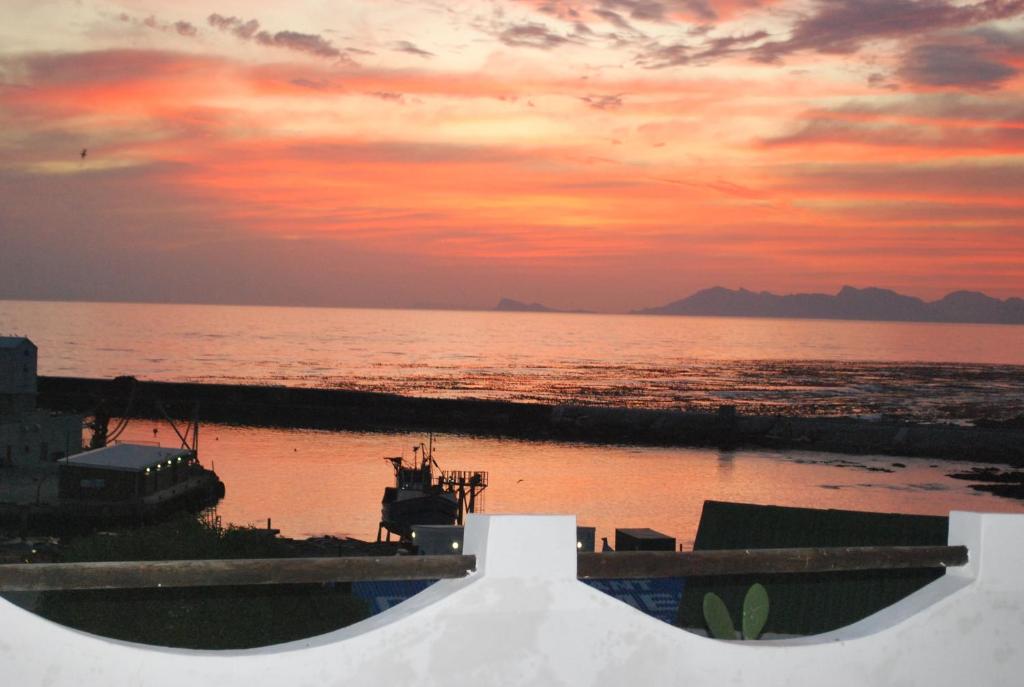 a view of the ocean with a sunset in the background at Saxon Lodge in Gansbaai