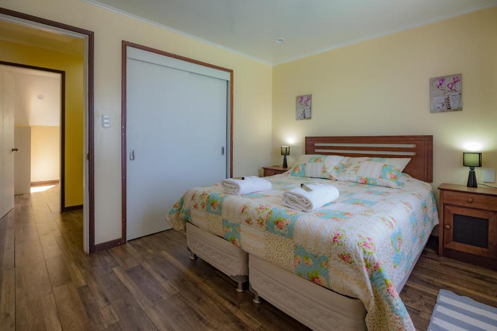 ein Schlafzimmer mit einem Bett mit zwei Handtüchern darauf in der Unterkunft Apartamentos Entre Fronteras in Punta Arenas