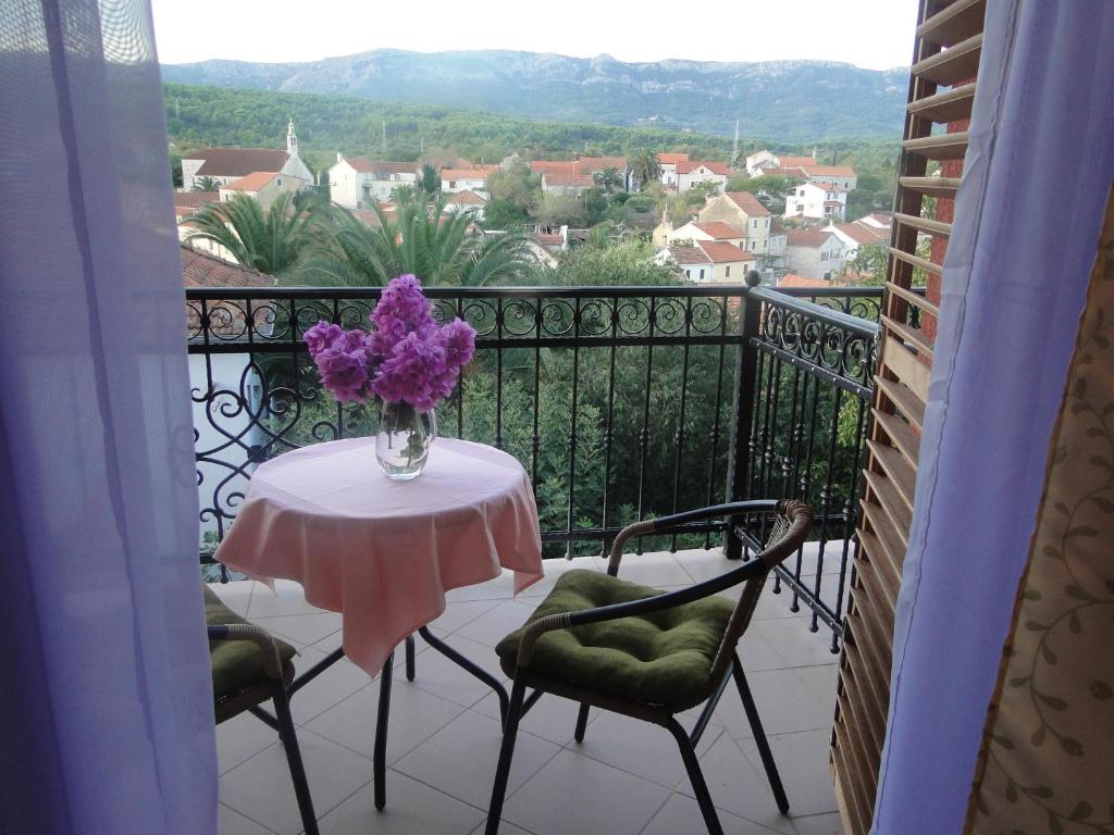 a table with a vase of purple flowers on a balcony at Villa Agava in Vrboska
