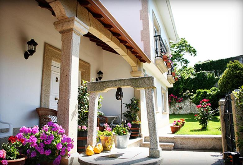 a porch of a house with flowers on it at Casa Lourido Lires in Lires