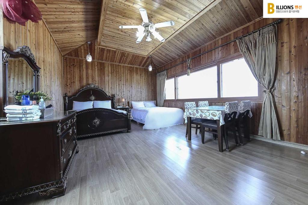 a bedroom with a bed and a ceiling fan at Billions Motel in Gangneung