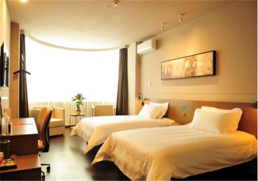 a hotel room with two beds and a window at Jinjiang Inn Dali Erhai Lake Park in Dali