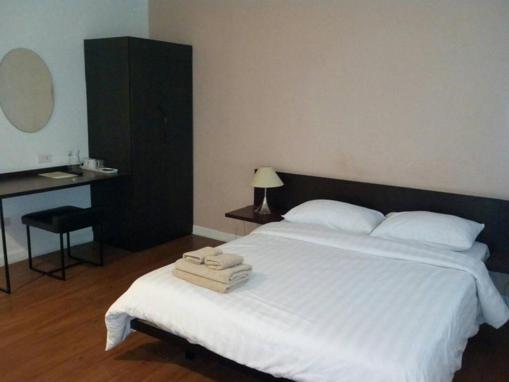um quarto com uma grande cama branca com toalhas em G9bangkok em Bangkok