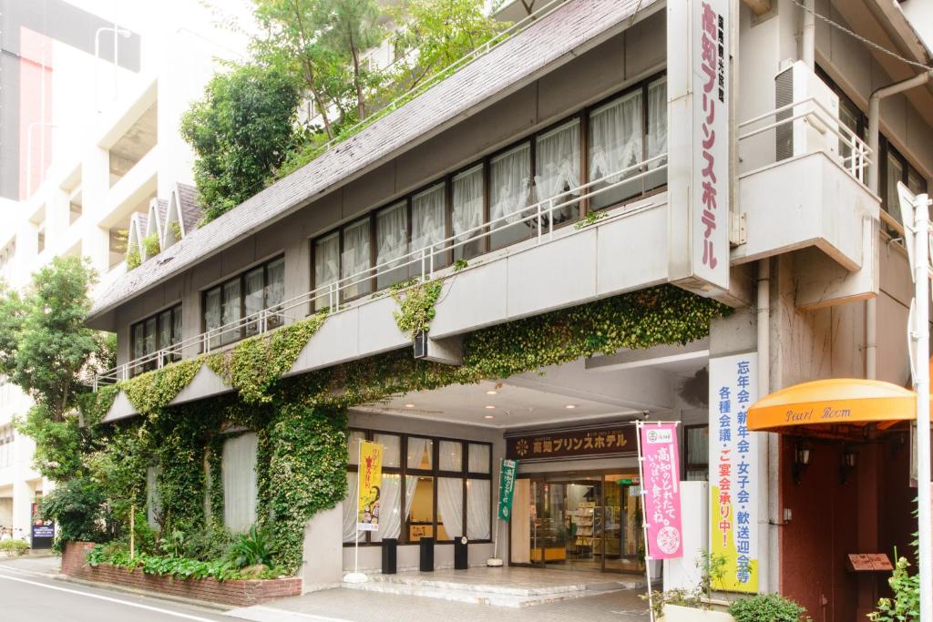 un bâtiment avec du lierre sur son côté dans l'établissement Kochi Prince Hotel, à Kōchi