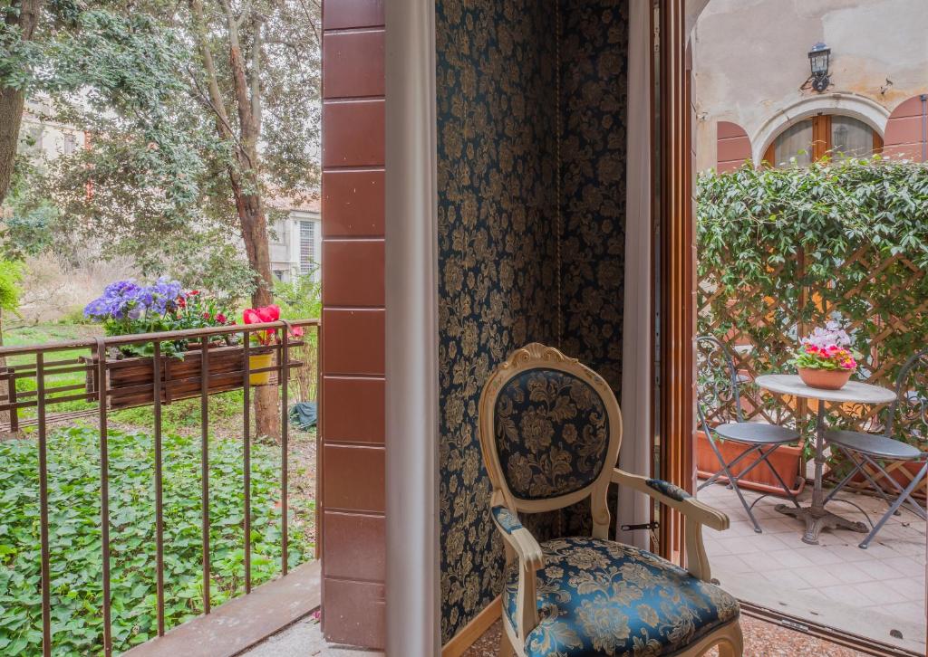 a chair sitting on a porch next to a fence at Hotel Il Mercante di Venezia in Venice