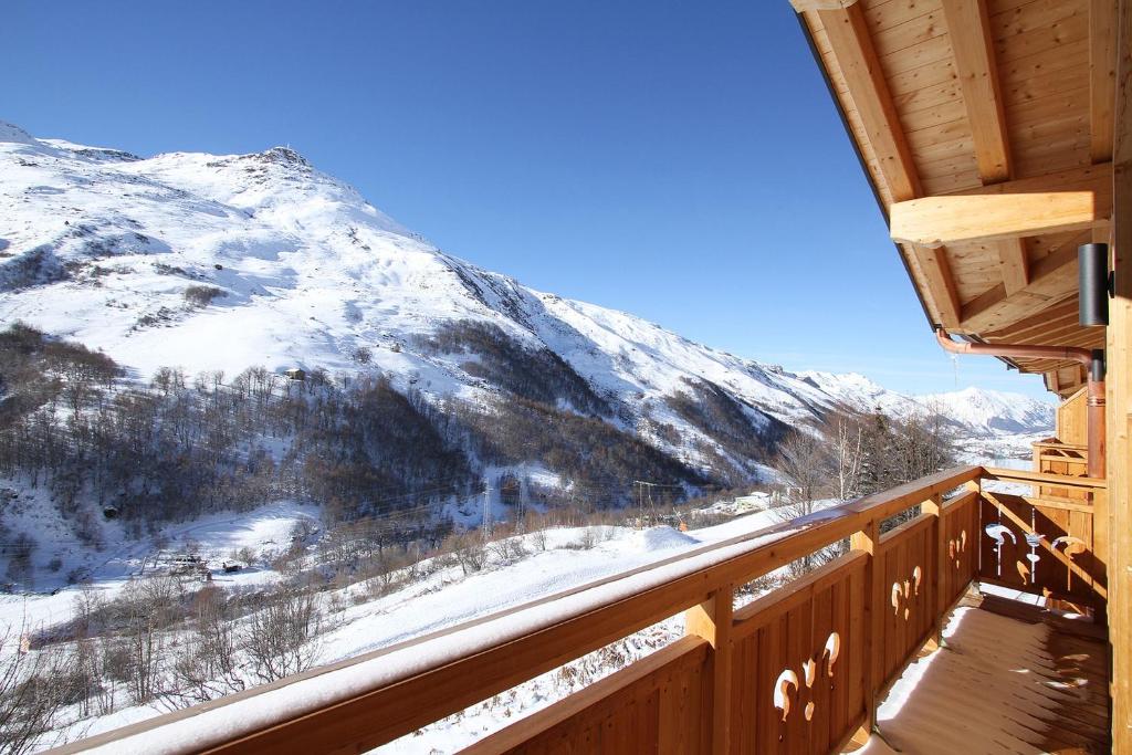 Elle comprend un balcon offrant une vue sur une montagne enneigée. dans l'établissement Odalys Chalet De Sophie, aux Menuires