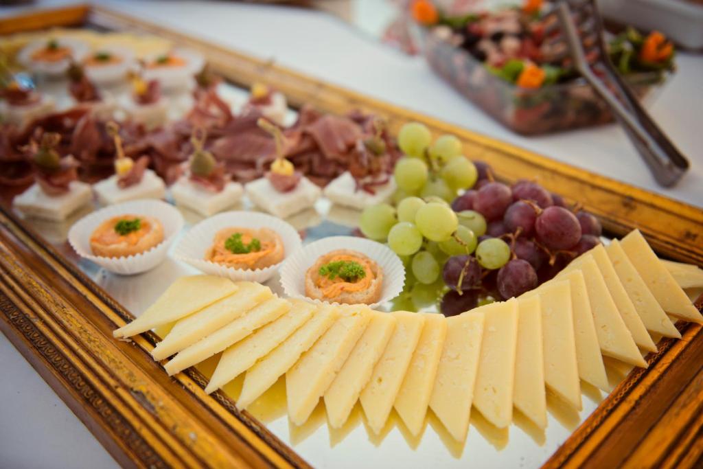 a tray of food with cheese and grapes on a table at Captain's Villa Sokol in Lumbarda