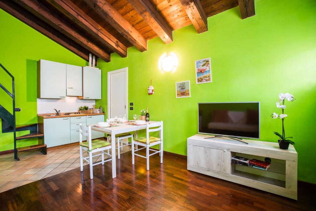 デセンツァーノ・デル・ガルダにあるGardappartamenti Carducci City Centreの白いテーブルと緑の壁が備わるキッチン