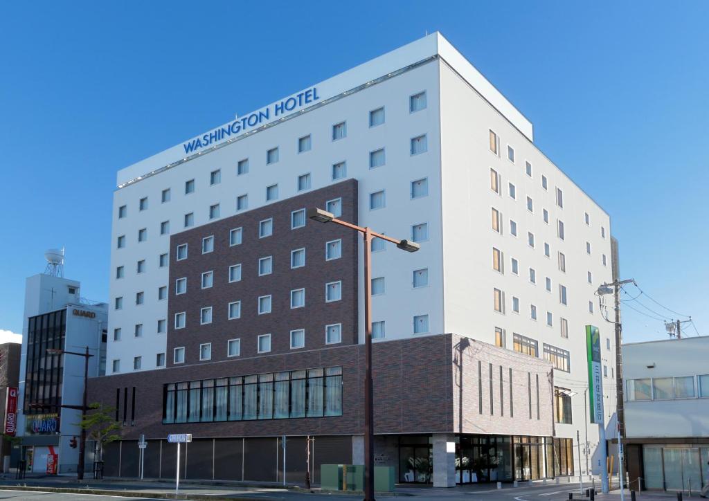 a large white building on a city street at Kisarazu Washington Hotel in Kisarazu