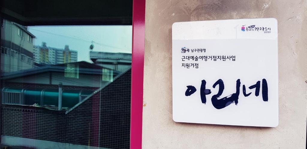 um sinal na lateral de um edifício com uma janela em Ariene Guesthouse em Gwangju