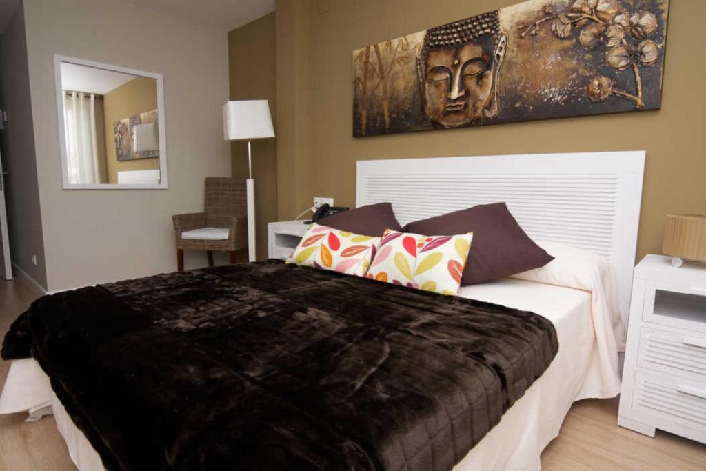 um quarto com uma cama grande e um quadro na parede em Hospedería el Puerto em Colindres