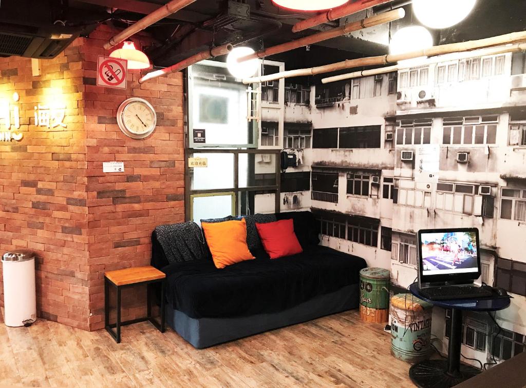 un divano in una camera con muro di mattoni di Yesinn @YMT a Hong Kong