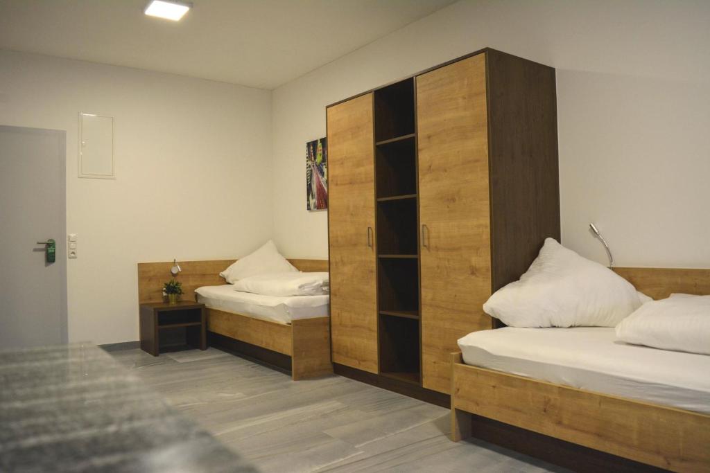 1 dormitorio con 2 camas y un gran armario de madera en Wels Inn Hotel, en Wels