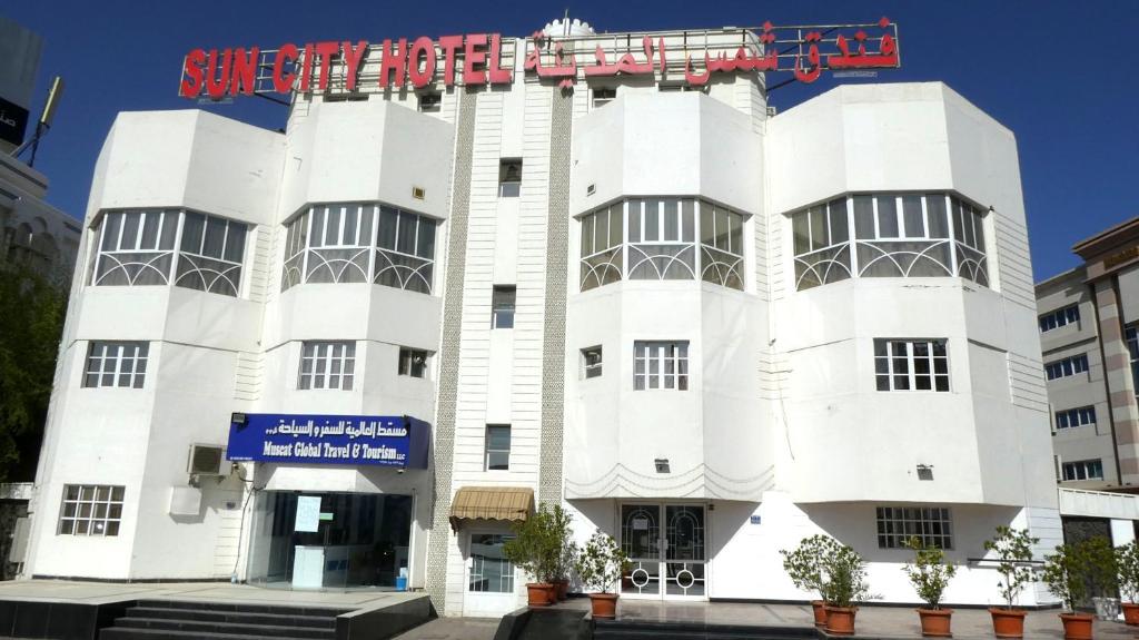 a white building with a sign on it at Sun City Hotel in Muscat