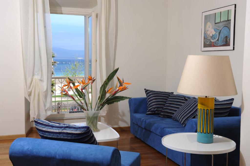 a living room with a blue couch and a window at Quarté Sayàl in Alghero