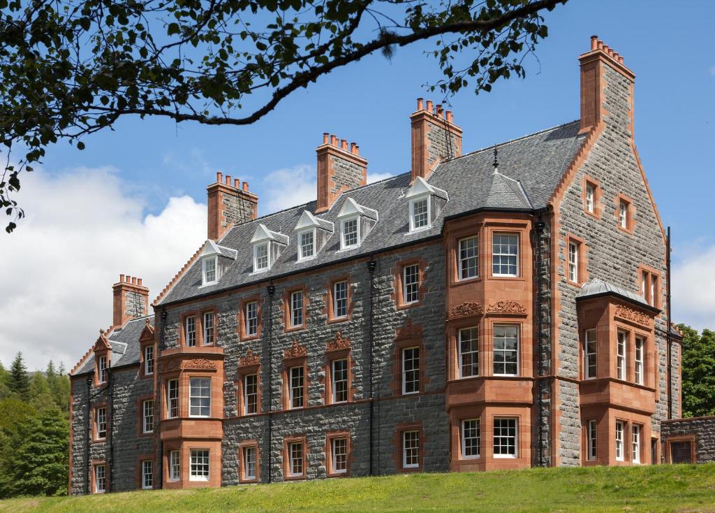 un grande edificio in mattoni con quattro camini di Glencoe House a Glencoe