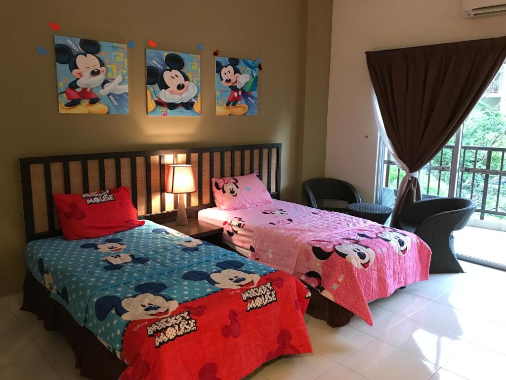 a bedroom with two beds with hello kitty sheets at Gold Coast Morib Mickey House in Banting